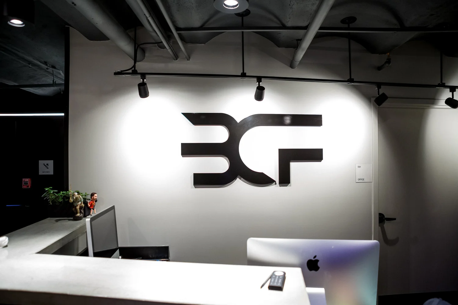 The BCF® logo wall behind the check-in desk at BronCore Fitness